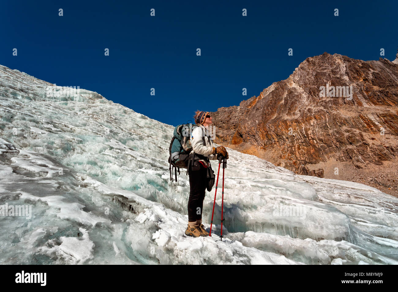 Mujer trekking sobre el glaciar en el Himalaya Foto de stock