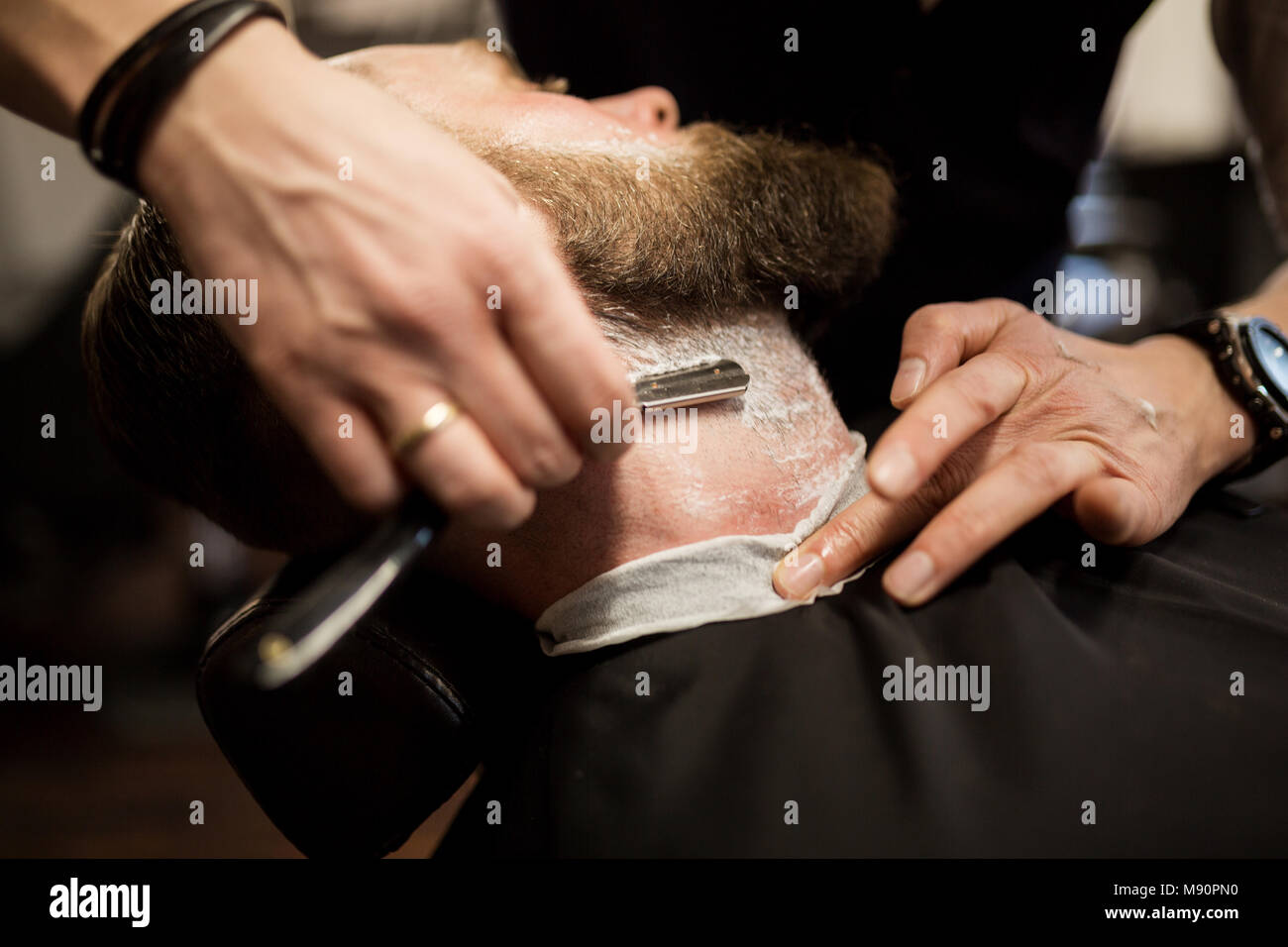 Retrato del hombre barbado siendo afeitado con maquinilla de afeitar Foto de stock