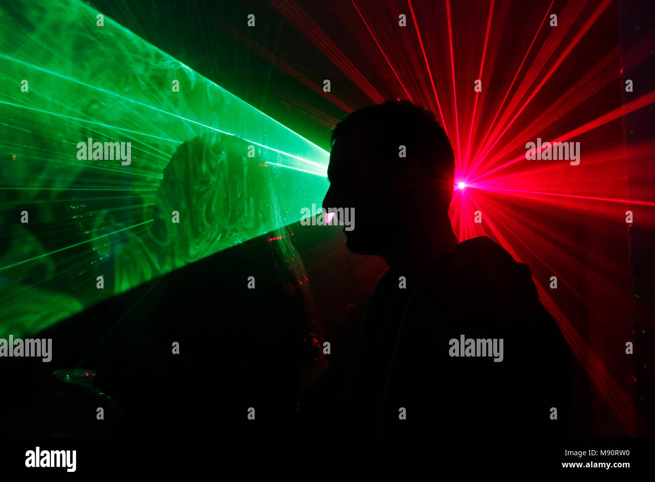 Silueta de un hombre a bailar a una discoteca con luces láser. Foto de stock