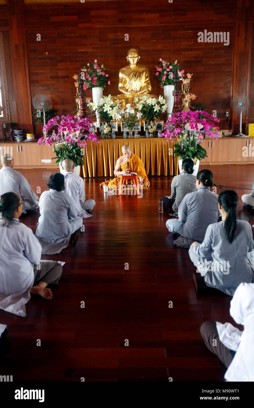Dang Quang Minh templo budista. Un profesor encarga a un grupo de personas cómo recitar cánticos budistas. Ho Chi Minh city. Vietnam. Foto de stock