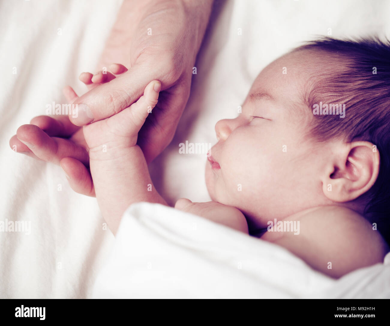 Feliz Recien Nacido Bebe Durmiendo Y Sosteniendo La Mano De Su Padre Fotografia De Stock Alamy