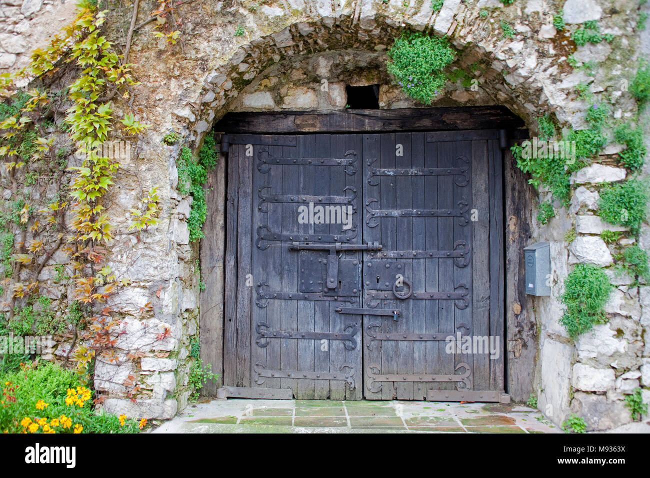 Antigua puerta de madera medievales con soportes de hierro forjado, casco antiguo del municipio La Turbie, Sur de Francia, Var, Provenza, Costa Azul, Francia, Europa Foto de stock