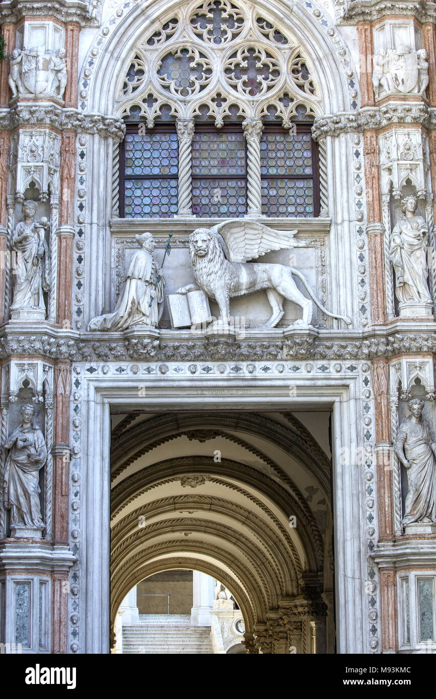 Las estatuas de mármol del león alado (el símbolo de Venecia) y el duque Francesco Foscari encima de la puerta de papel (Porta della Carta) del Palacio Doge en Foto de stock