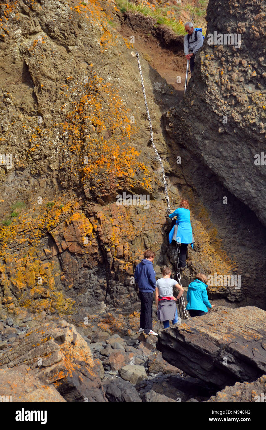 Un grupo de personas hacer el paseo en la cadena costera rocosa Elie, Fife Foto de stock