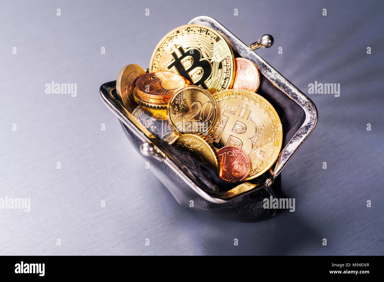 Monedero Bitcoin llena con dos y muchas monedas de euro Foto de stock