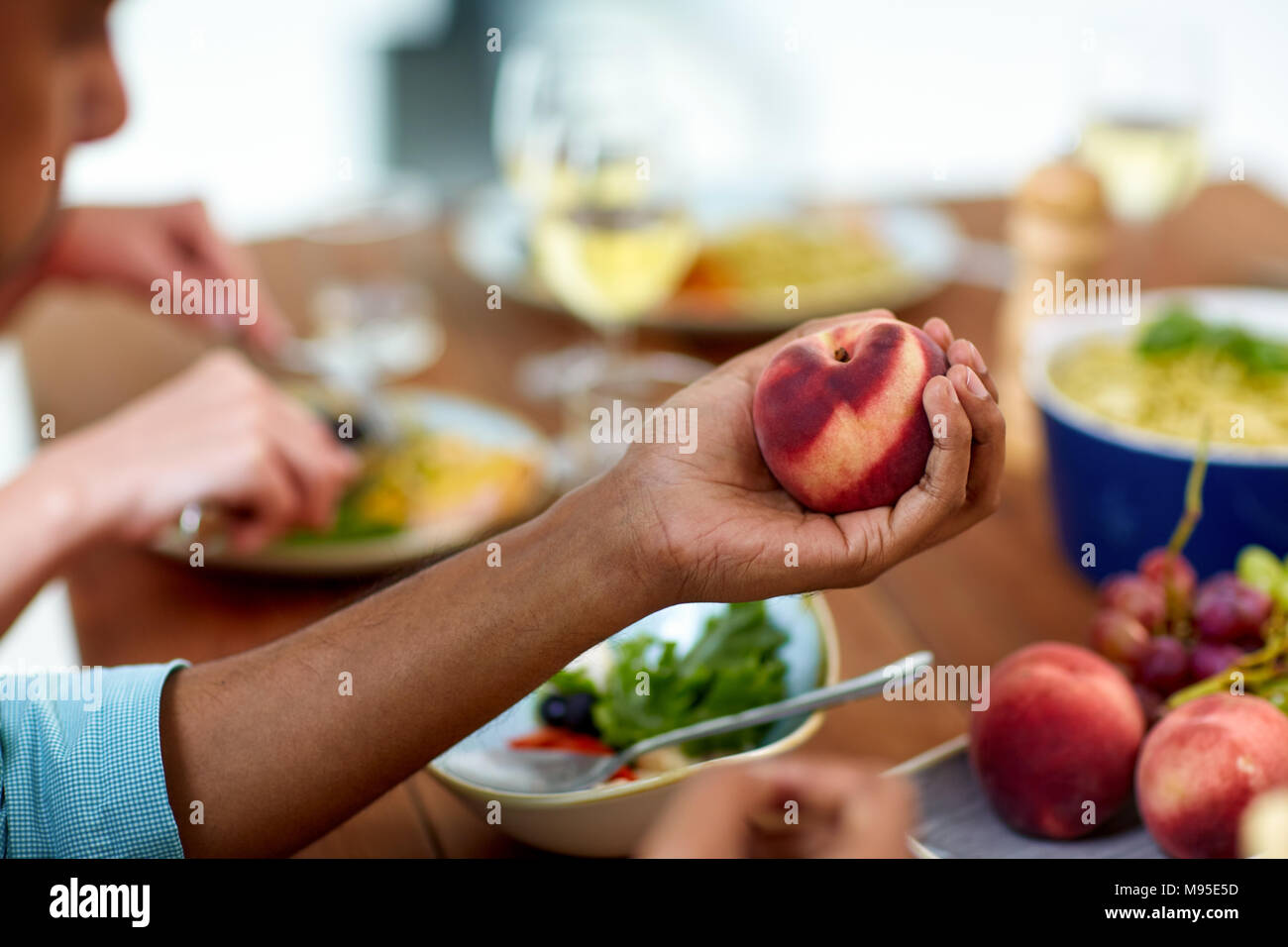Young man eating peach fotografías e imágenes de alta resolución Foto