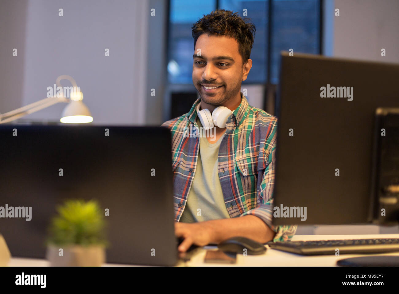 Hombre creativo con portátil trabajando de noche office Foto de stock