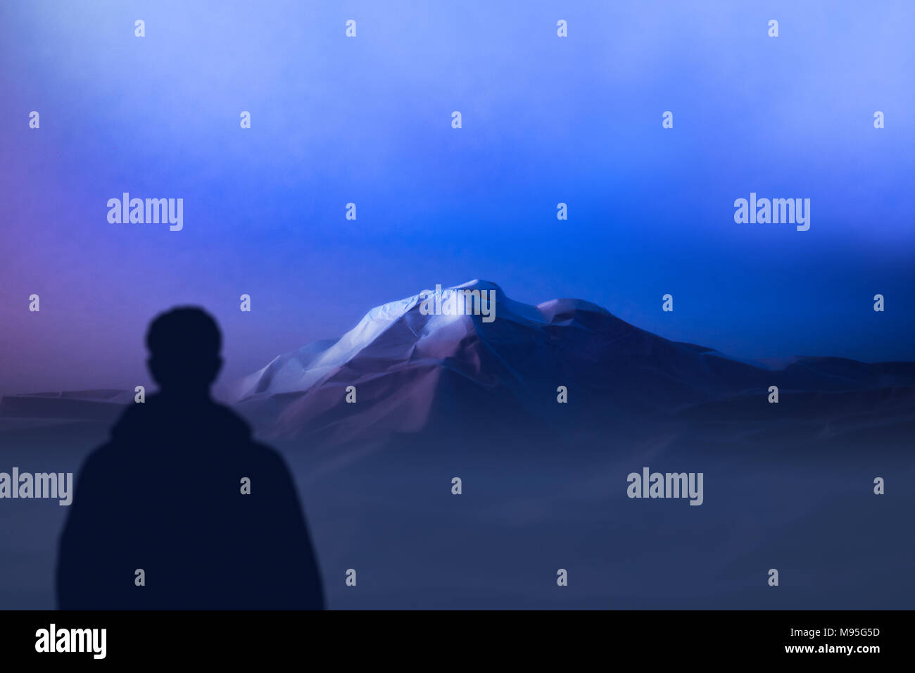 Silueta escalador se encuentra en las montañas de pie mirando de alta montaña. expedición al Himalaya paisaje nocturno Foto de stock