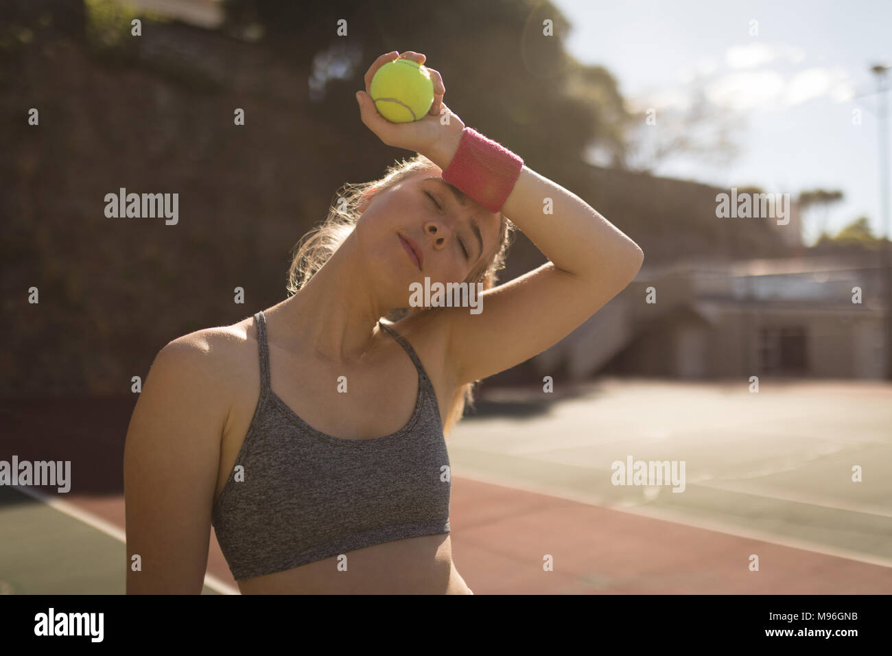 Mujer sudoración mientras juega al tenis en la pista de tenis. Foto de stock