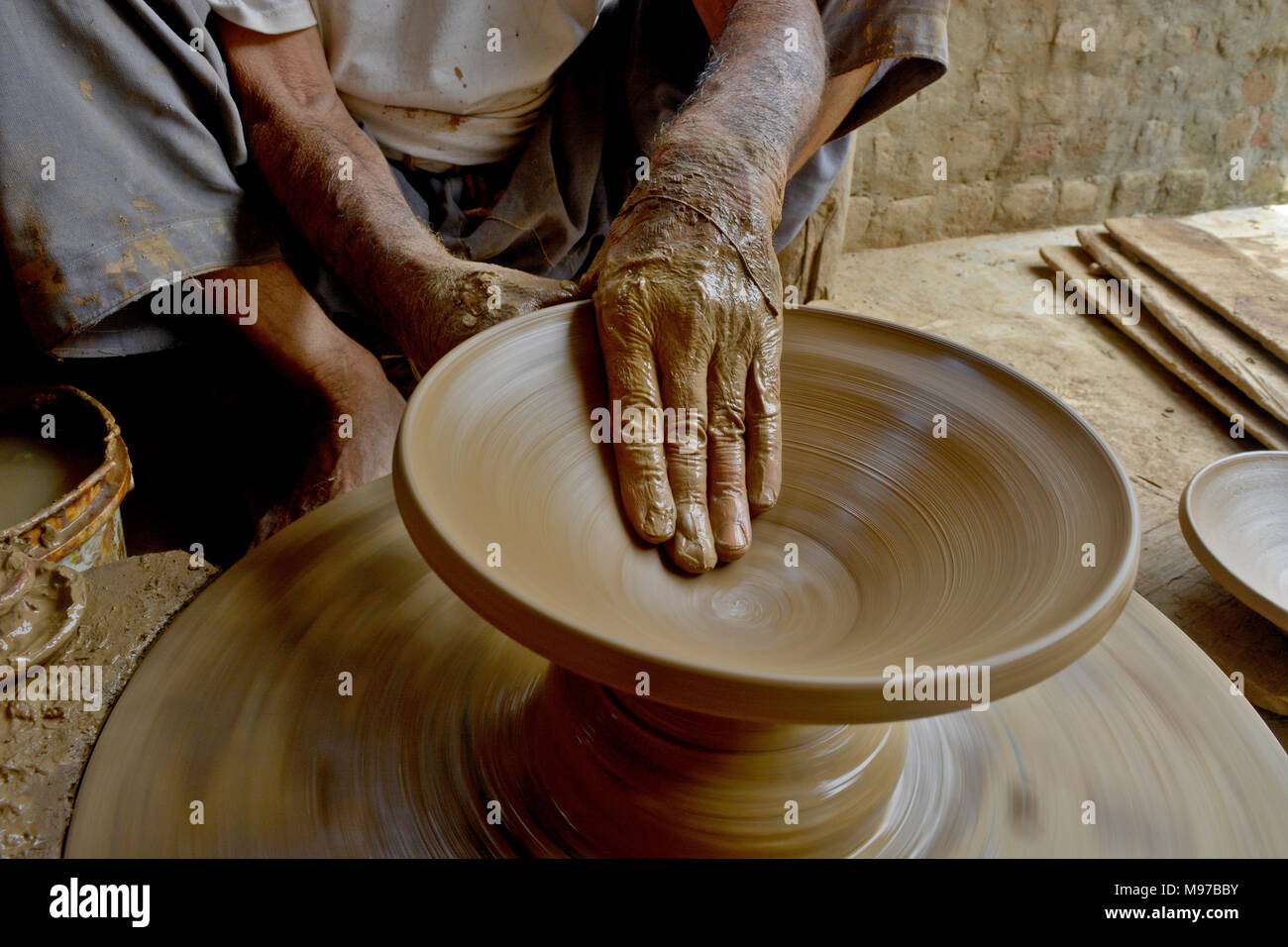 Olla de barro alfarero de Cachemira en un torno de alfarero tradicional en  su taller en las afueras de Srinagar, la capital de verano de Cachemira  administrada por India. Fabricación de vasijas