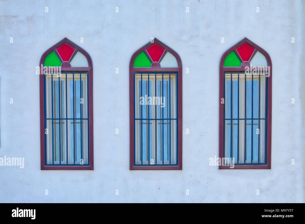 Antiguo, colorido estilo Árabe windows en trillizos - Muscat, Omán. Foto de stock