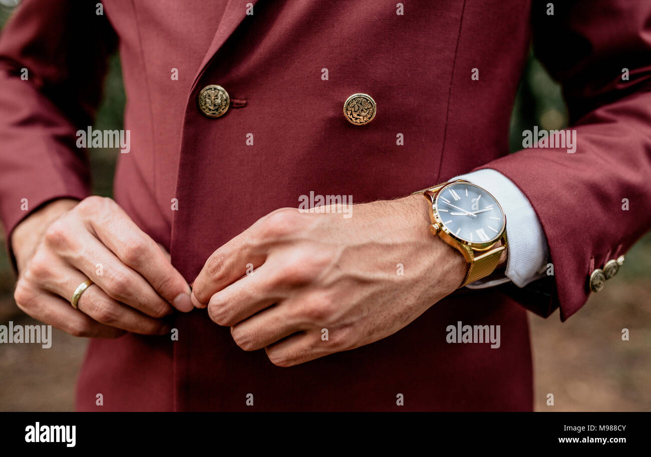 Cerca del hombre vistiendo un traje y reloj de oro para abotonarse la  chaqueta Fotografía de stock - Alamy