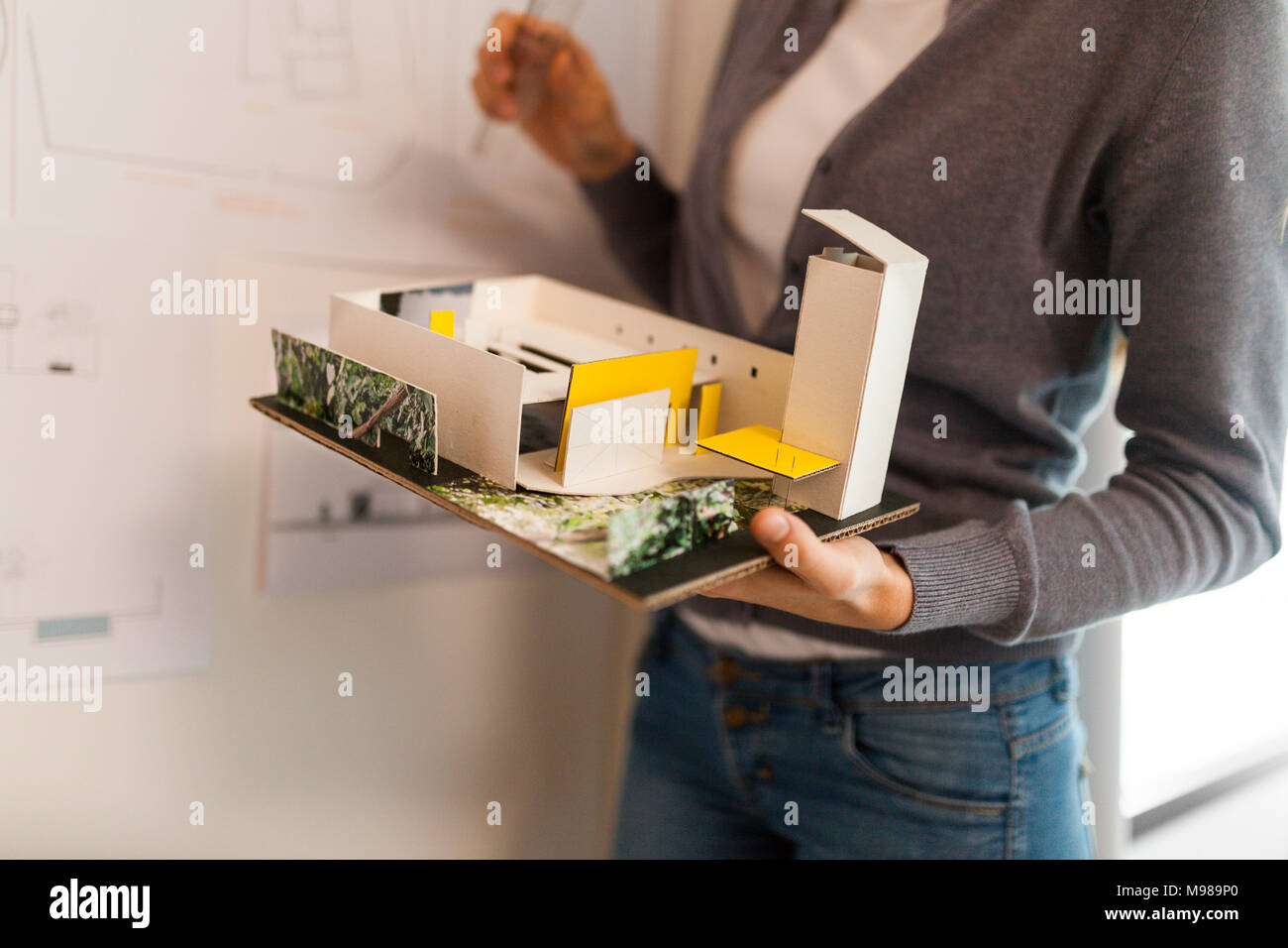 Mujer trabajando en un proyecto de arquitecto, sosteniendo el modelo arquitectónico Foto de stock