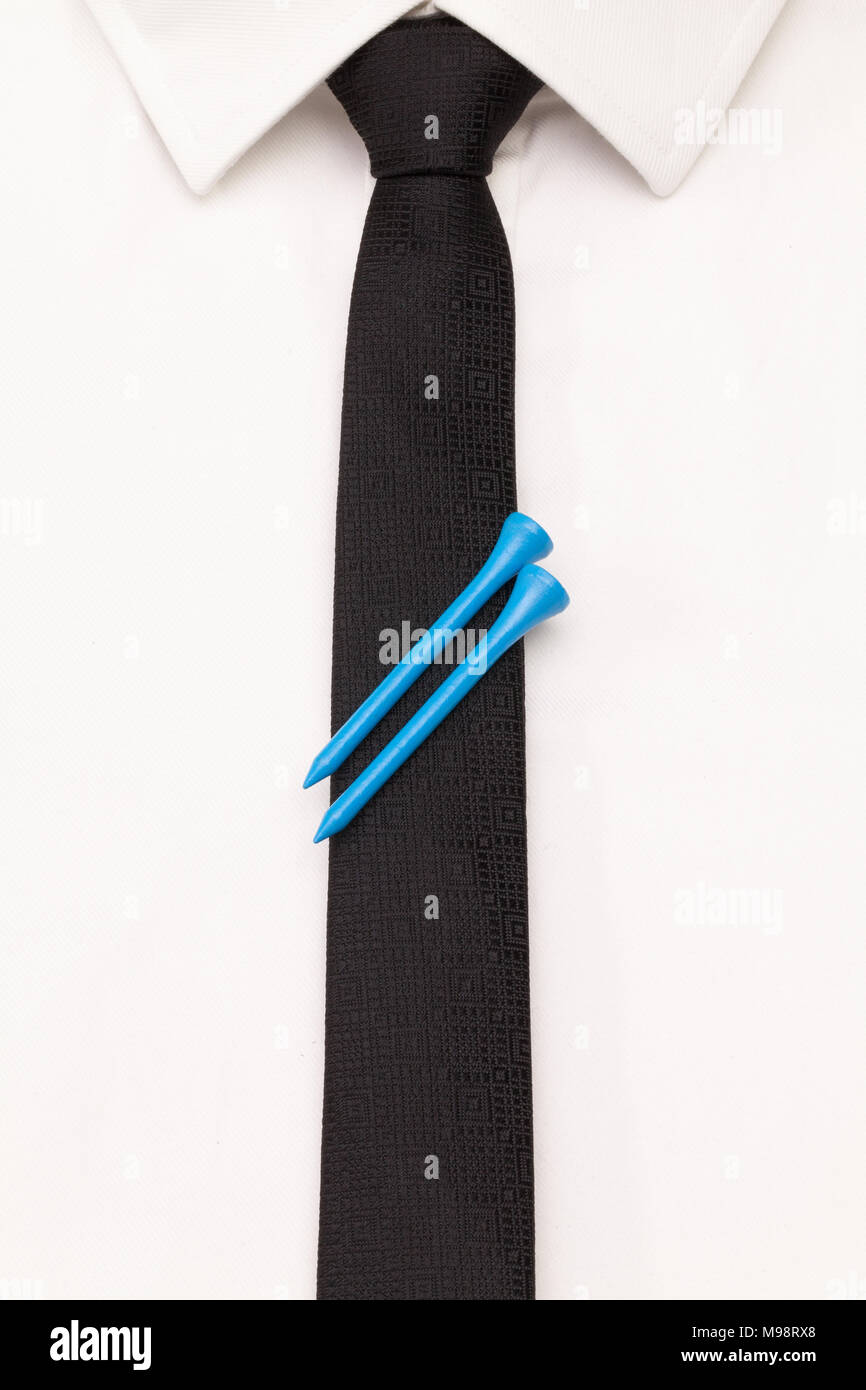 El detalle de la camisa blanca y corbata negra con golf design. Blue golf tees en el black tie. Foto de stock