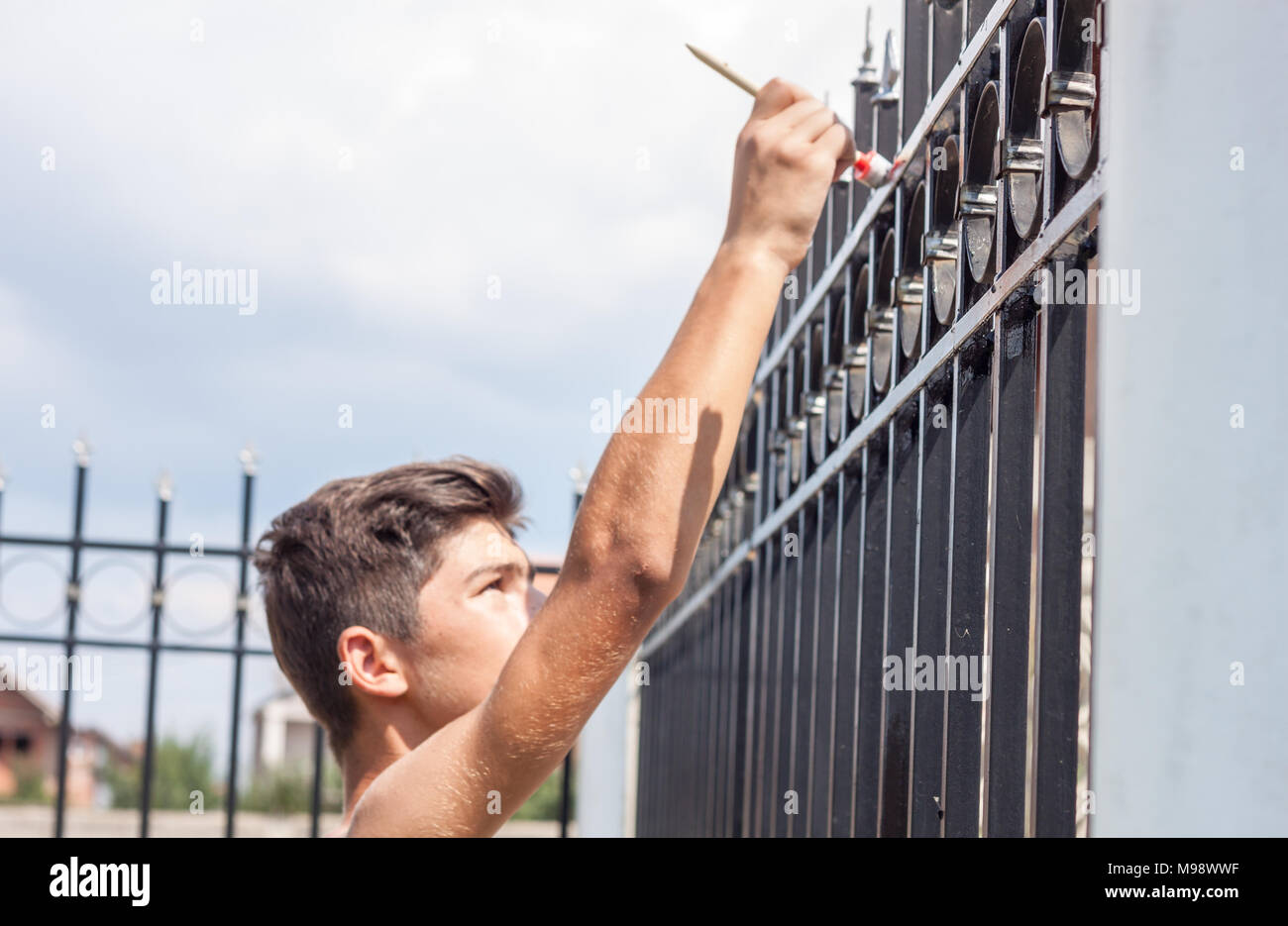 Boy pintar la valla metálica de jardín Fotografía de stock - Alamy