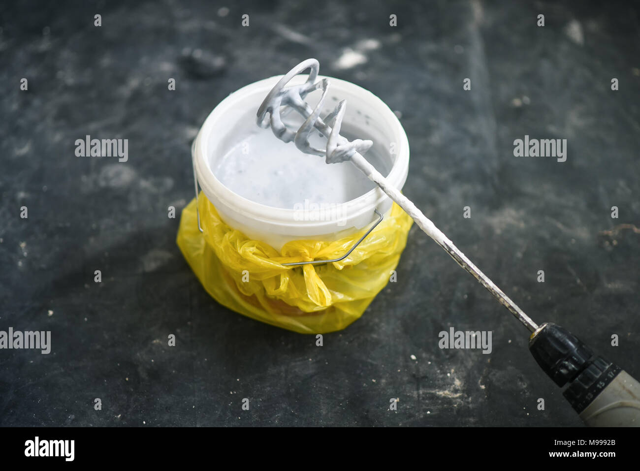 Taladro mezclador de paleta en una cubeta con pintura blanca, herramientas  y accesorios de bricolaje Fotografía de stock - Alamy