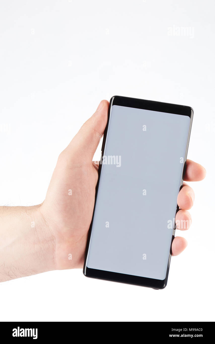 Smartphone con pantalla grande en la mano close-up aislados sobre fondo blanco. Foto de stock