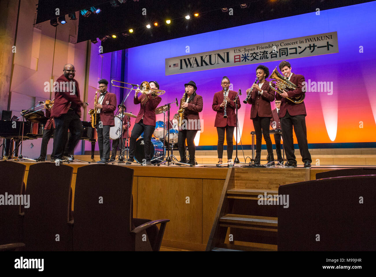 Strawbridge Allen, maestro de música de Matthew C. Perry High School, dirige a sus estudiantes en su rendimiento de "Funky Town/me siento bien" durante la octava edición de EE.UU.-Japón amistad Concierto en La Sinfonia de Iwakuni Concert Hall en la ciudad de Iwakuni, Japón, el 24 de febrero, 2018. El evento permitió a los estudiantes de diferentes culturas se juntan para llevar a cabo y tener la oportunidad de crear conexiones a través de la música, a pesar de la barrera del idioma. (Ee.Uu. Marine Corps Foto de stock