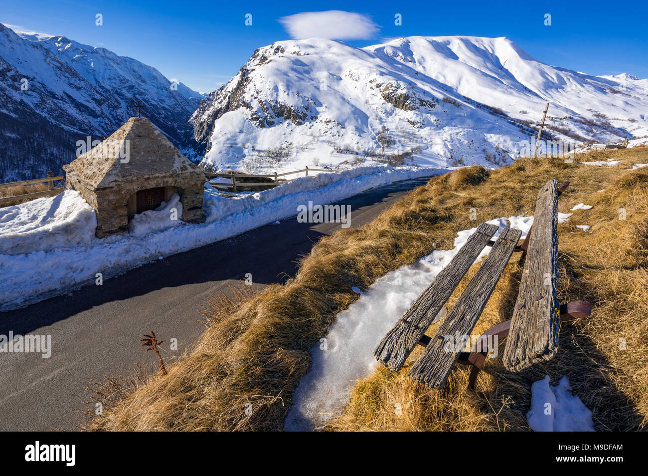 El Oratorio de carretera Le Chazelet y un viejo banco de madera en invierno. Parque Nacional de Ecrins, región PACA Hautes-Alpes, Alpes, Francia Foto de stock