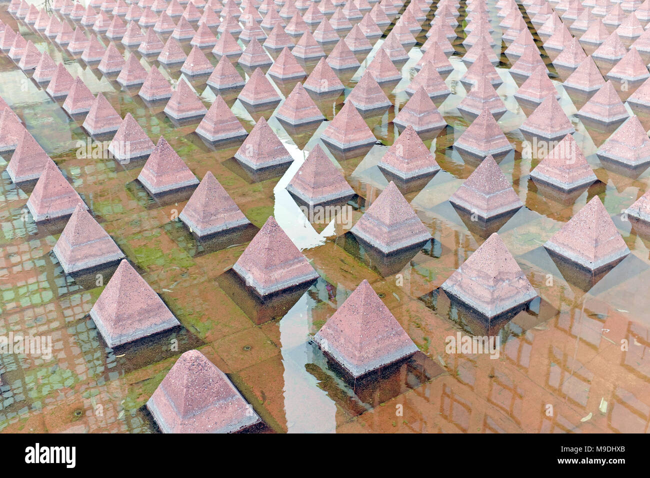 Más de 1000 pequeñas pirámides de concreto rojo quemado reflejadas en el agua, representando la construcción azteca usando piedra volcánica de Tezontle en Ciudad de México, México. Foto de stock