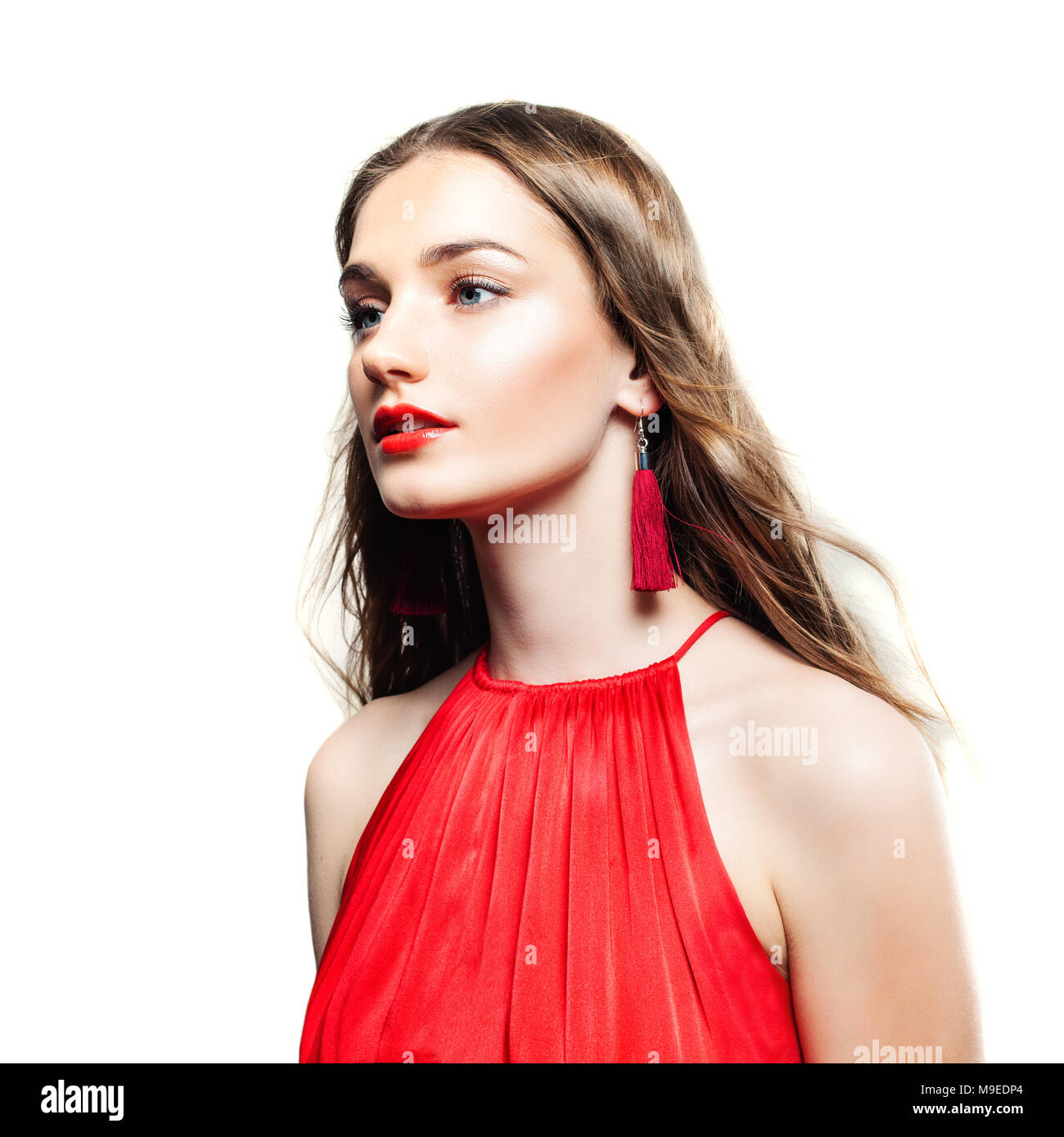 Modelo de Moda Mujer con aretes rojos, el pelo largo y aisladas de paño rojo  sobre fondo blanco Fotografía de stock - Alamy
