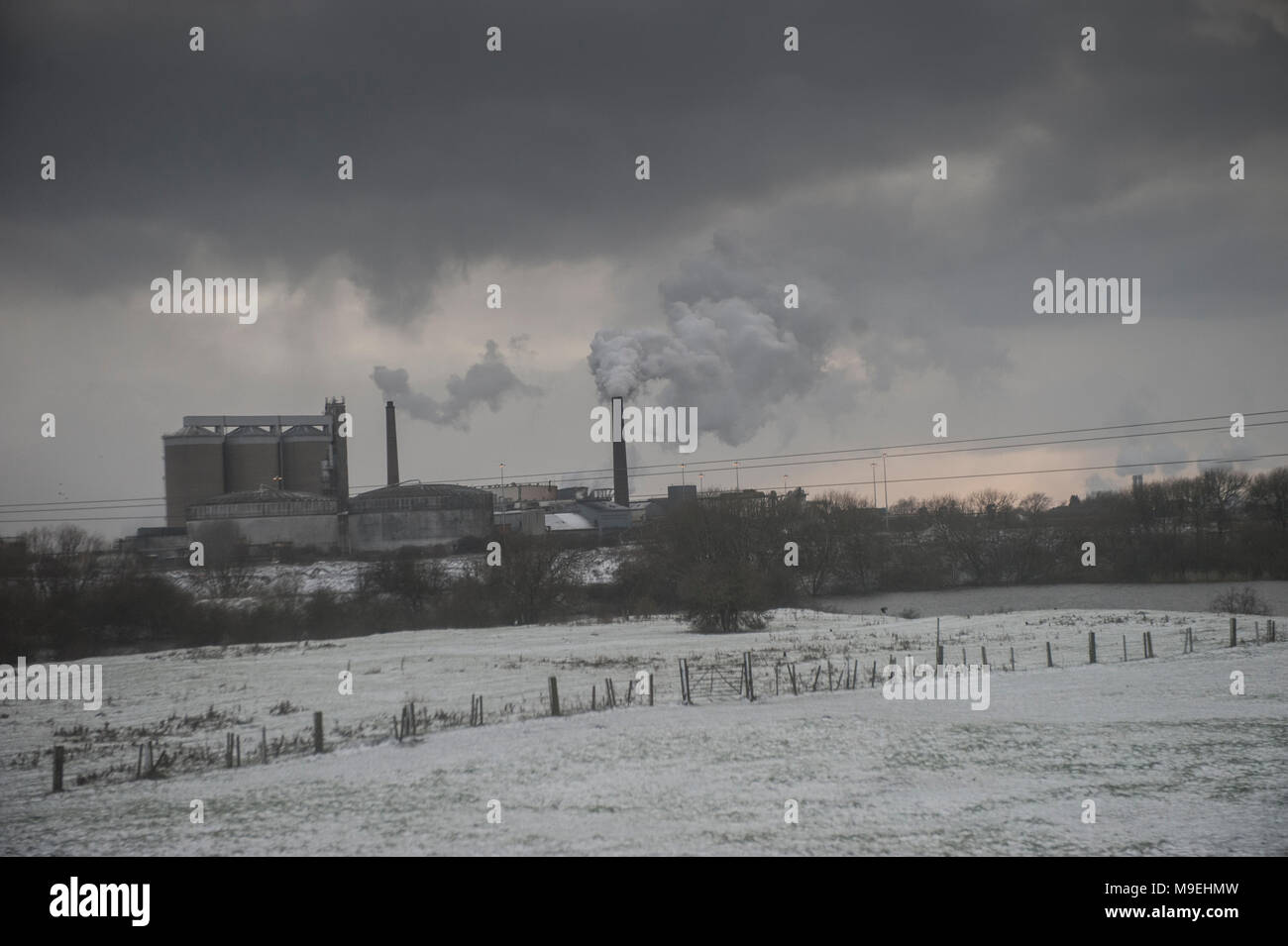 Campos nevados rodean una fábrica bombear contaminantes en el Foto de stock