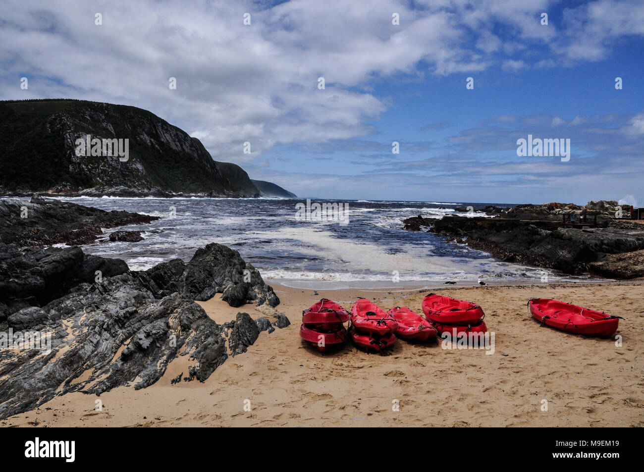 El paisaje y la playa del Parque Nacional Tsitsikamma con kayaks rojo listo para un tour de aventura. Ruta Jardín, Sudáfrica Foto de stock