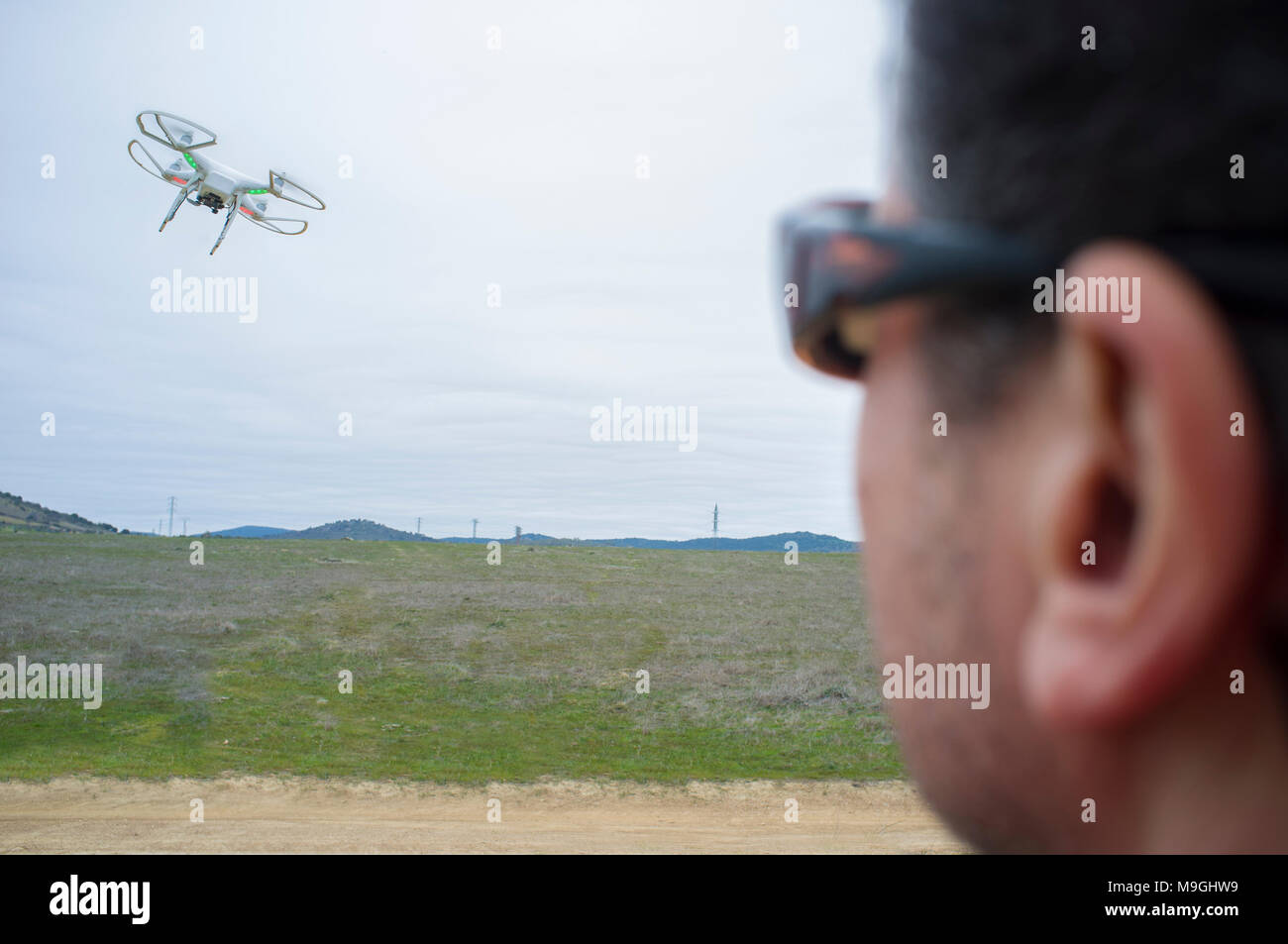 Piloto de drone un día nublado en la campiña. Acercándose a maniobrar con el balanceo excesivo Foto de stock