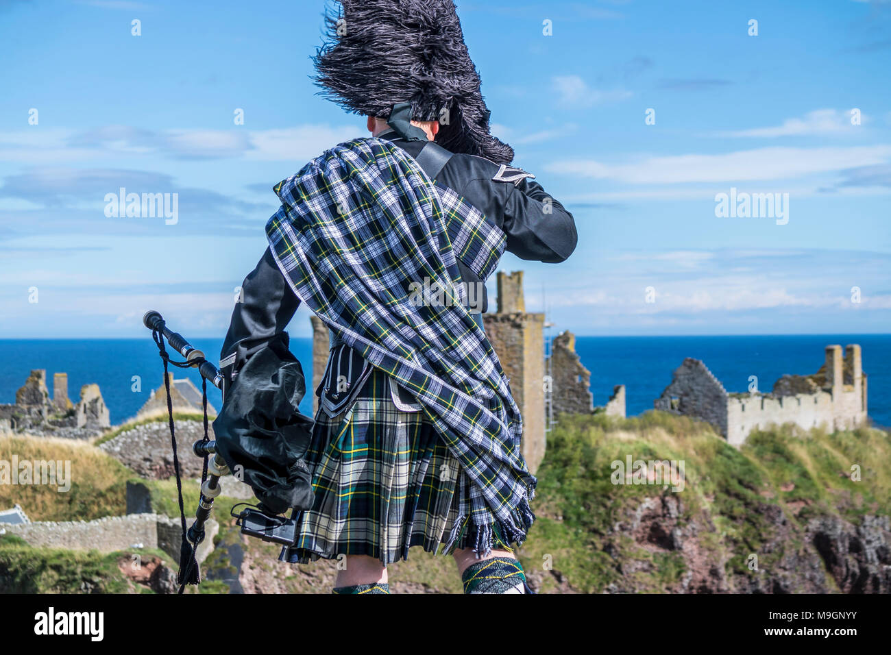 Gaiteiro escocés tradicional en su totalidad código de vestimenta en Dunnottar Castle en Stonehaven Foto de stock