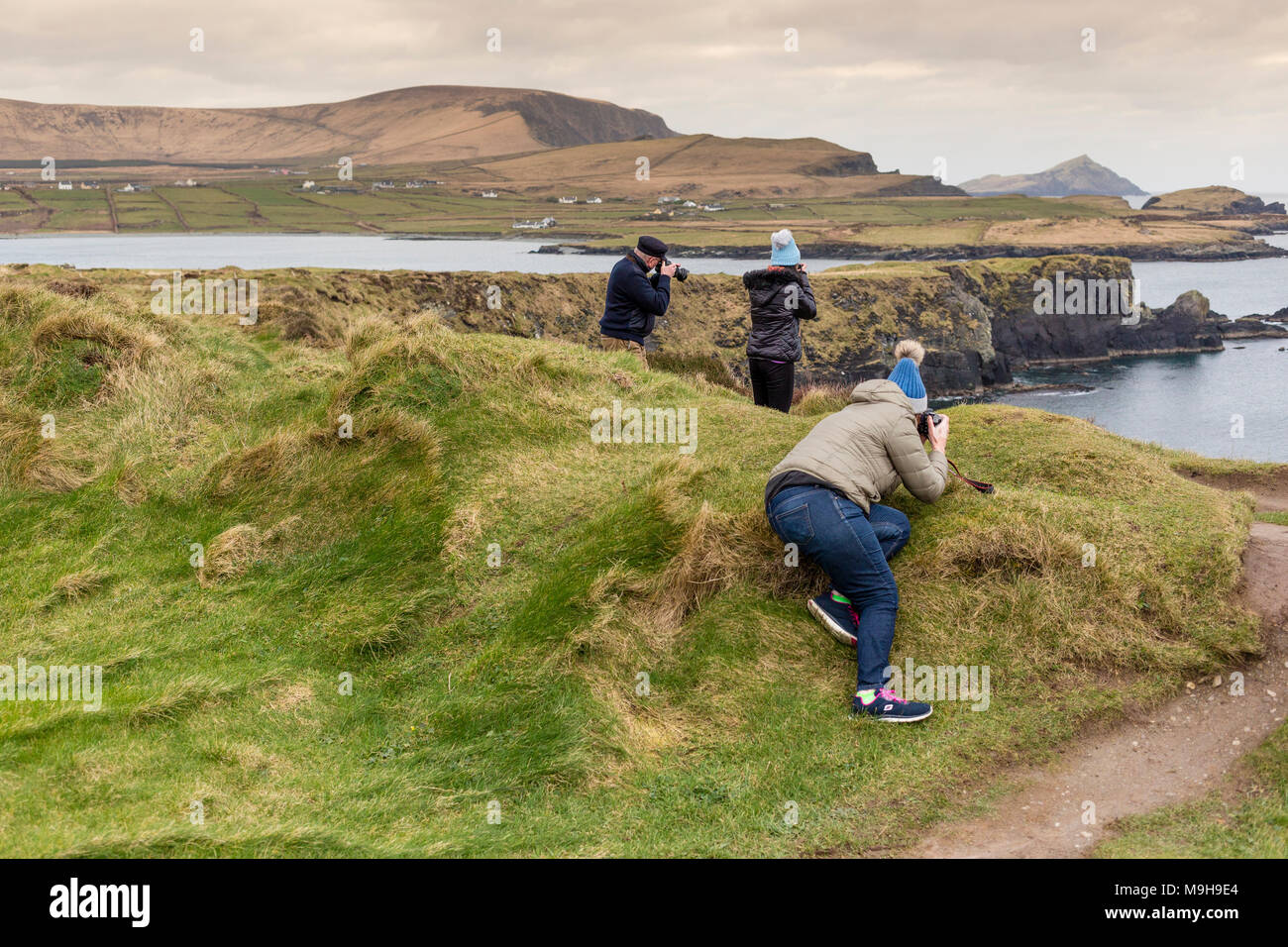 Tres personas, dos mayores y un menor, fotografiar paisajes en el condado de Kerry, Irlanda Foto de stock