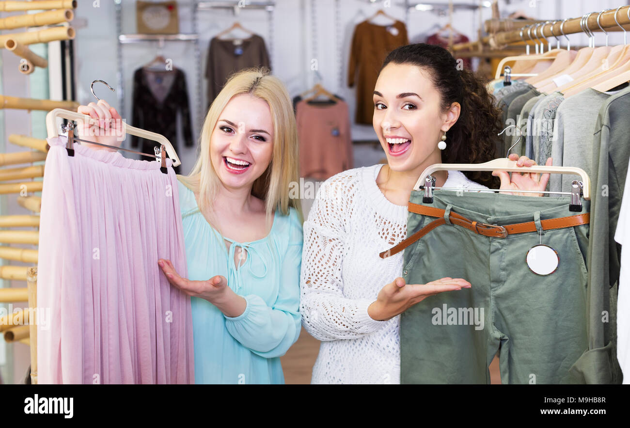Dos jóvenes ropa nueva en tienda. Centrarse en la morena Fotografía de stock - Alamy