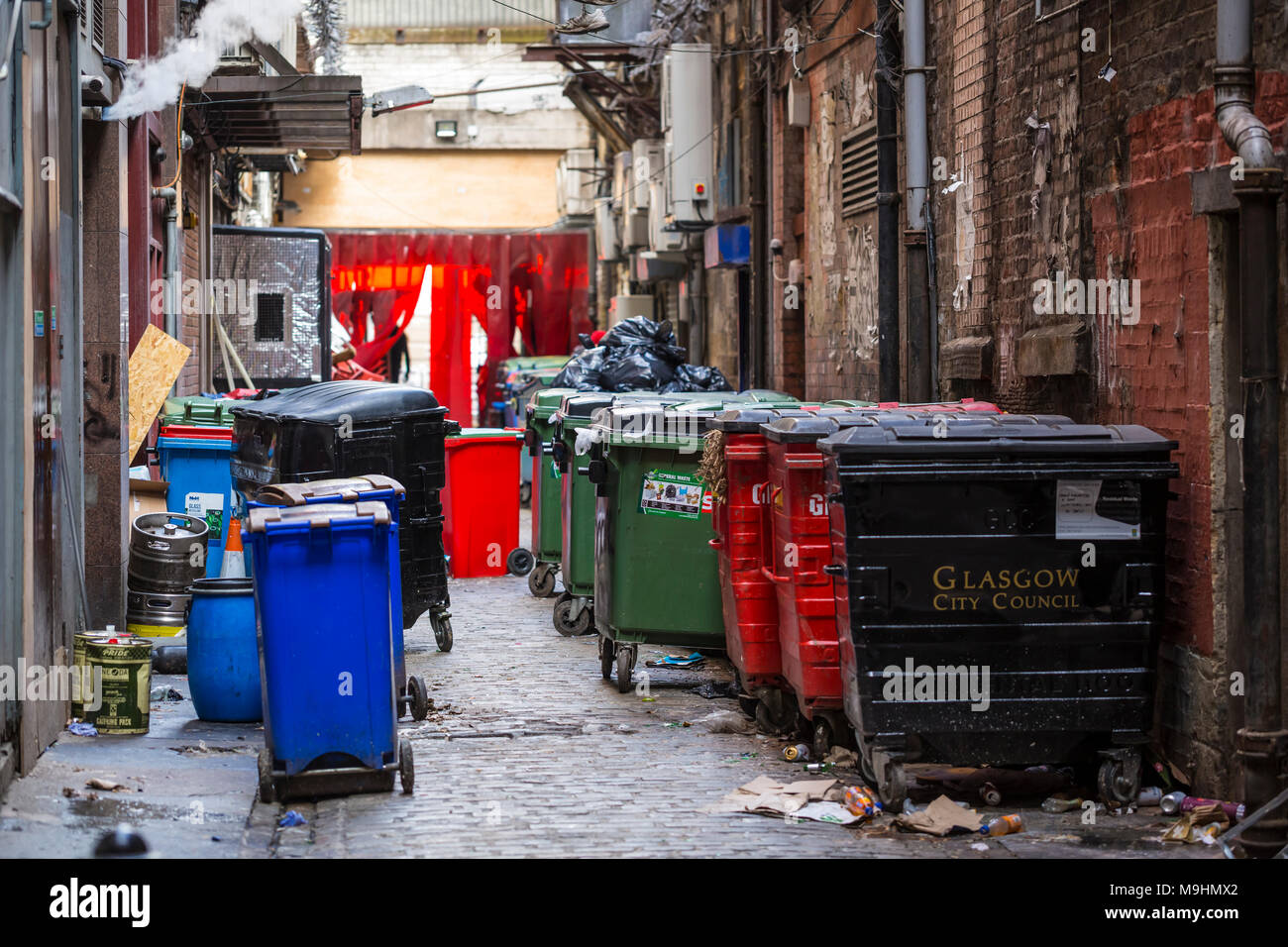 Contenedores de residuos comerciales en un callejón de Mitchell Lane en el centro de la ciudad de Glasgow, Escocia, Reino Unido Foto de stock