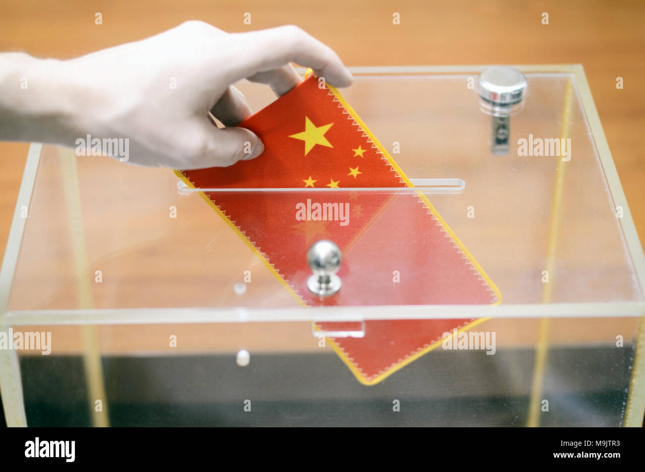 Hombre de insertar la bandera de China en la urna de votación, las votaciones y elecciones en China. Foto de stock