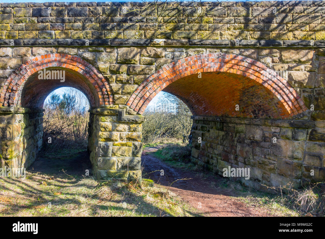 Un doble arco una espiral sentado en el puente de ladrillo antiguo Whitby a Scarborough en el ferrocarril Ravenscar Peakside Ladrillos North Yorkshire Foto de stock