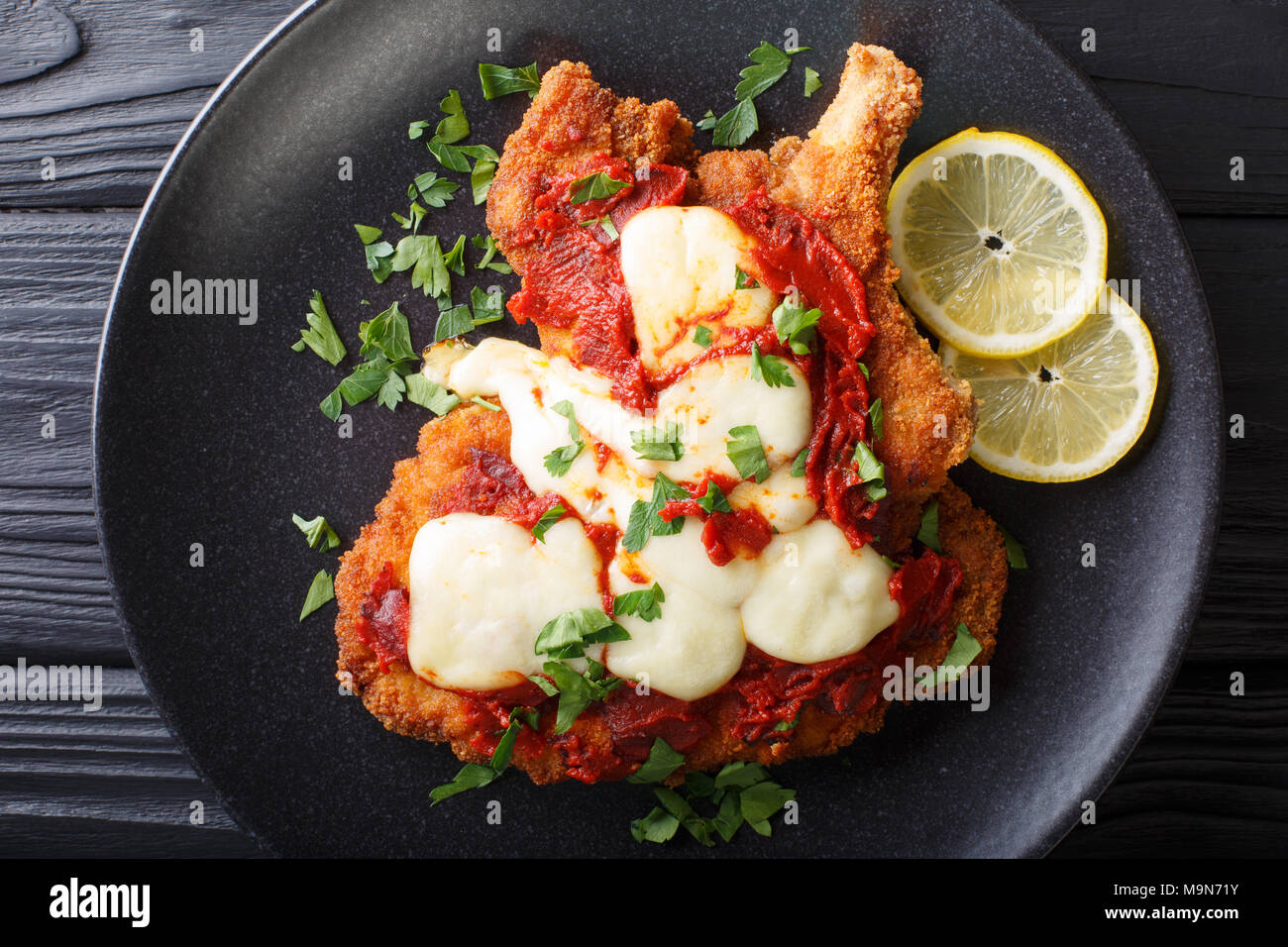 South American Food: Milanesa napolitana chuleta de ternera en pan rallado con queso mozzarella y salsa de tomate de cerca en una placa f vista superior horizontal. Foto de stock