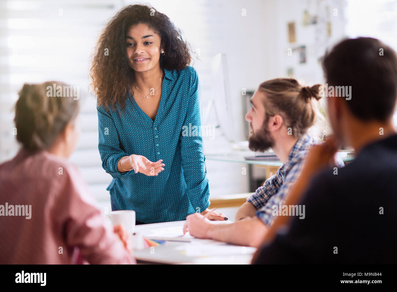 Reunión en la oficina. Una mujer negra de hablar con sus compañeros Foto de stock