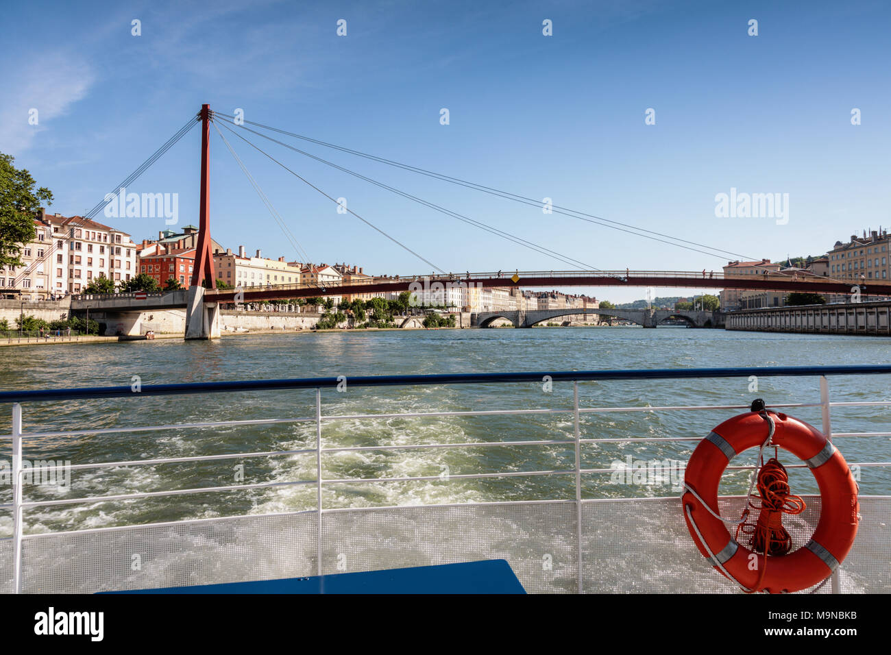 El Palacio de Justicia pasarela sobre el río Saône tomada desde la parte trasera de un crucero de placer en barco, Lyon, Francia. Foto de stock