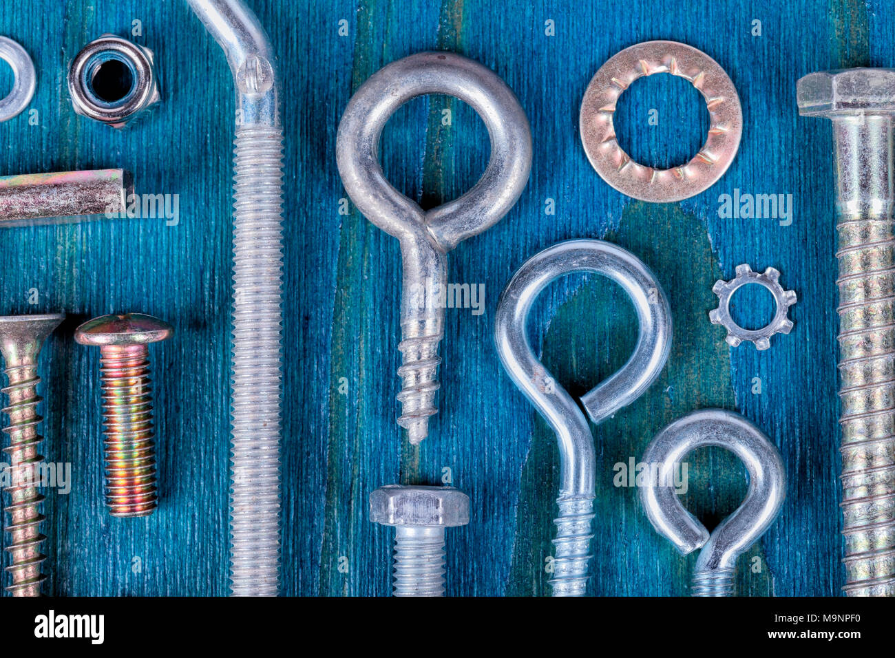 Tornillos tuercas y arandelas de diferentes tipos y medidas sobre fondo de  madera azul Fotografía de stock - Alamy