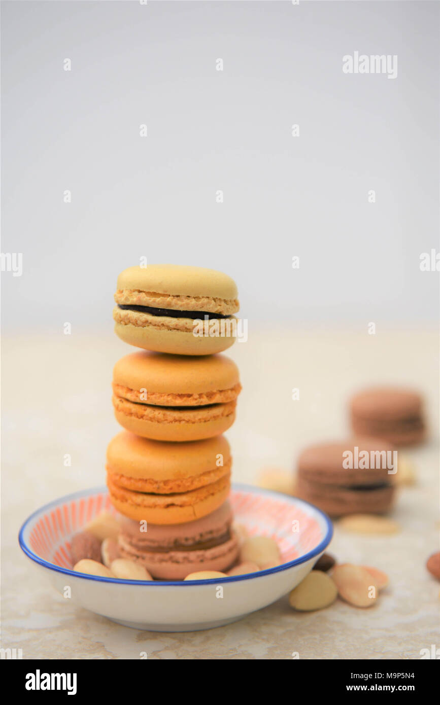 Chocolate y galletas macaroon sabor naranja sobre mármol blanco Foto de stock