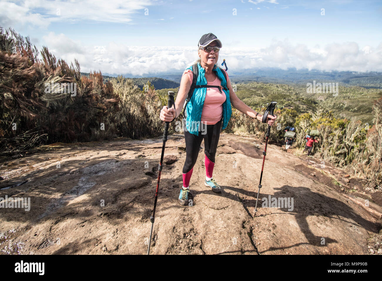 Mujer caminante tomar descanso en las laderas del Monte Kilimanjaro, Arusha, Tanzania Foto de stock