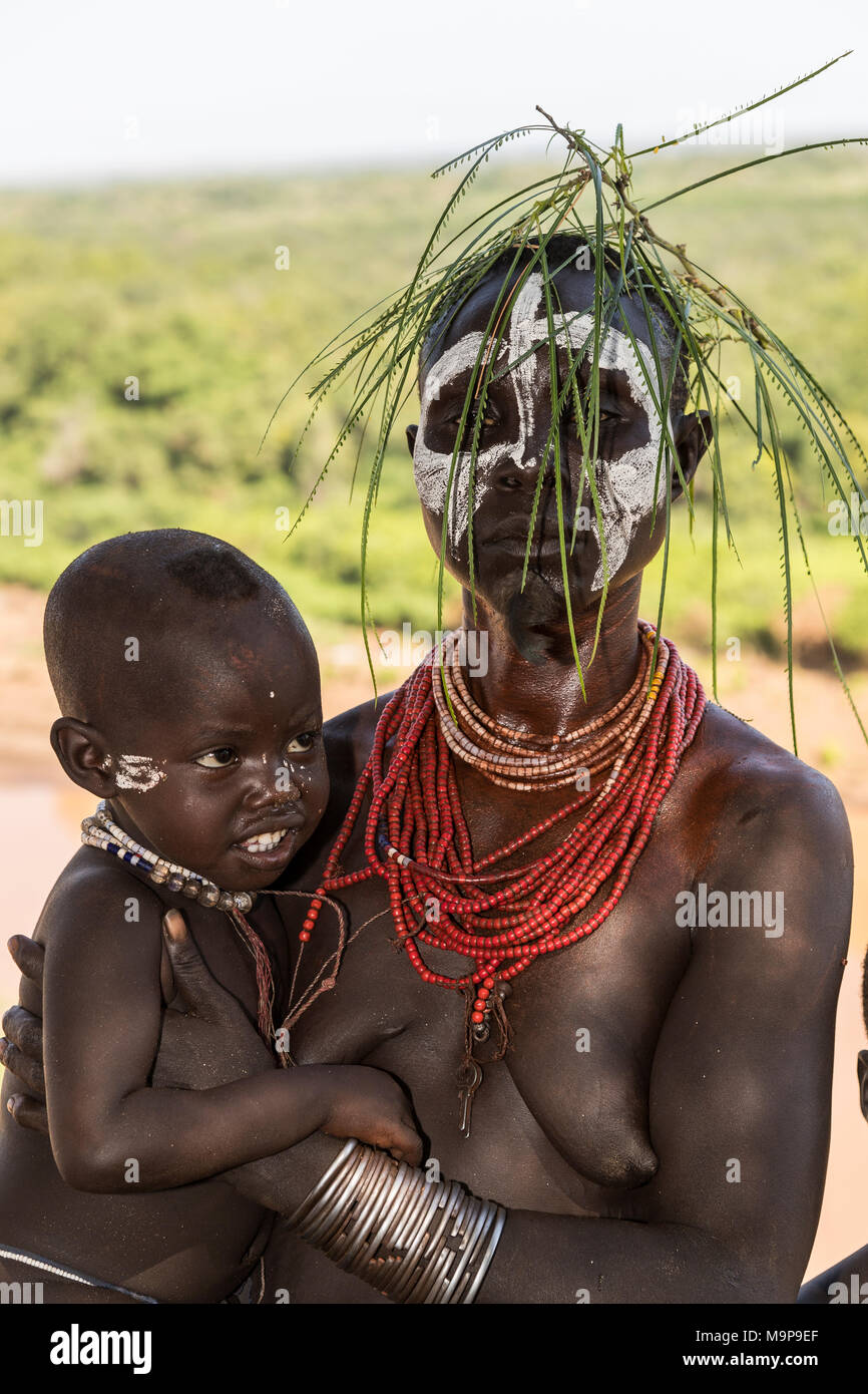 Mujer joven con un niño pequeño, con cabeza y collares, tribu Karo, omo River, las naciones del Sur las Nacionalidades y los pueblos de la región Foto de stock