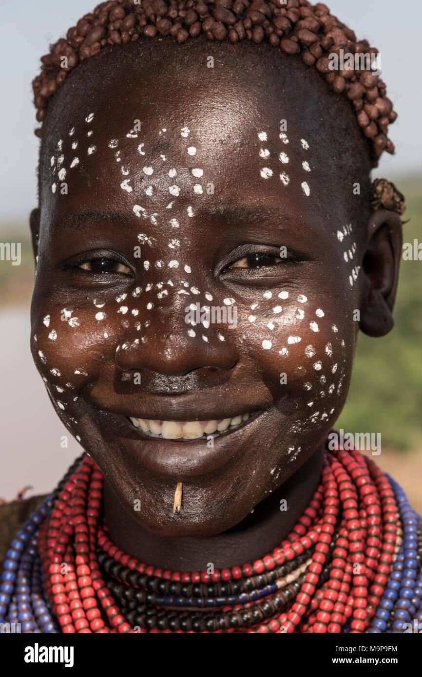 Mujer joven con pintura de cara, retrato, riendo, tribu Karo, las naciones del Sur las Nacionalidades y los pueblos de la región, Etiopía Foto de stock