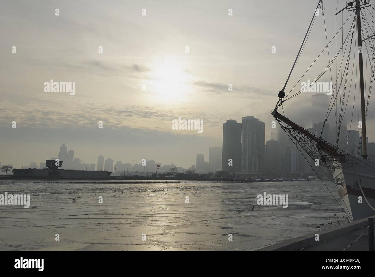 Invierno de Chicago skyline sobre el agua con la ciudad y el horizonte sobre el agua y la silueta del buque mástil en primer plano Foto de stock