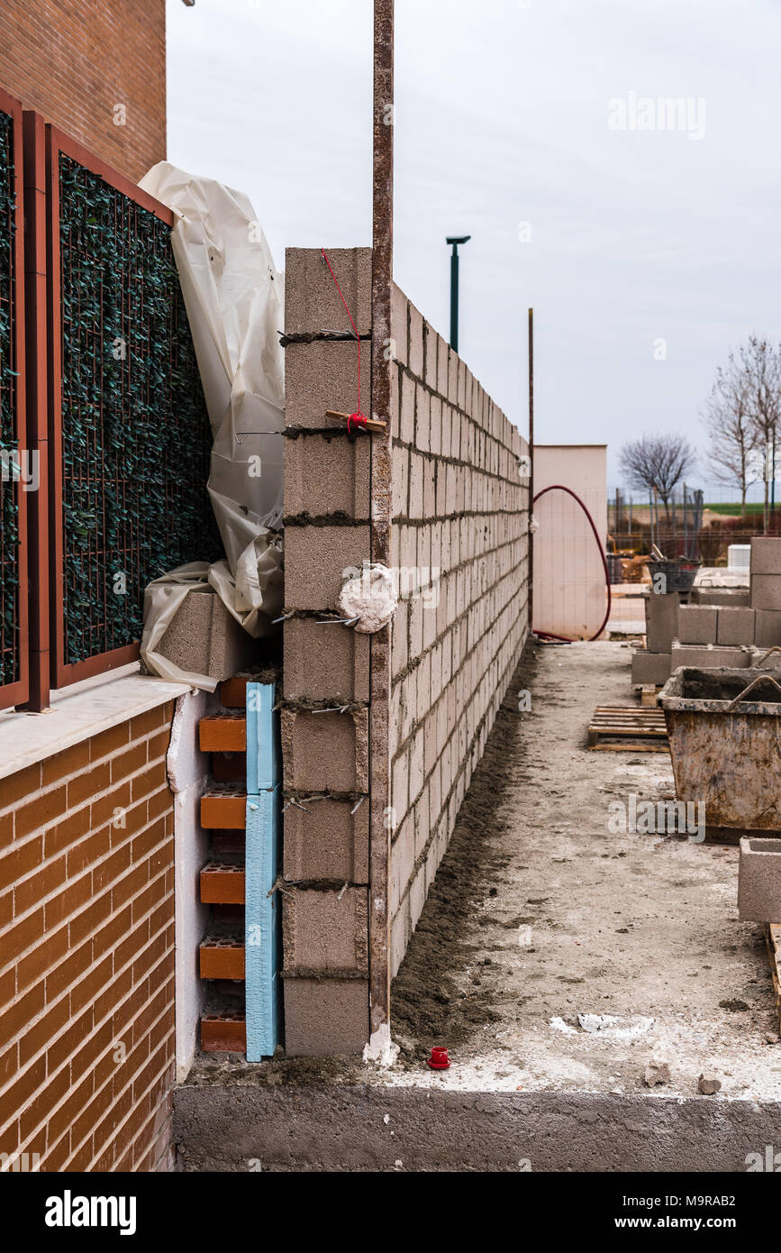 Las obras de construcción de pared de bloques de hormigón armado con aislamiento. Foto de stock