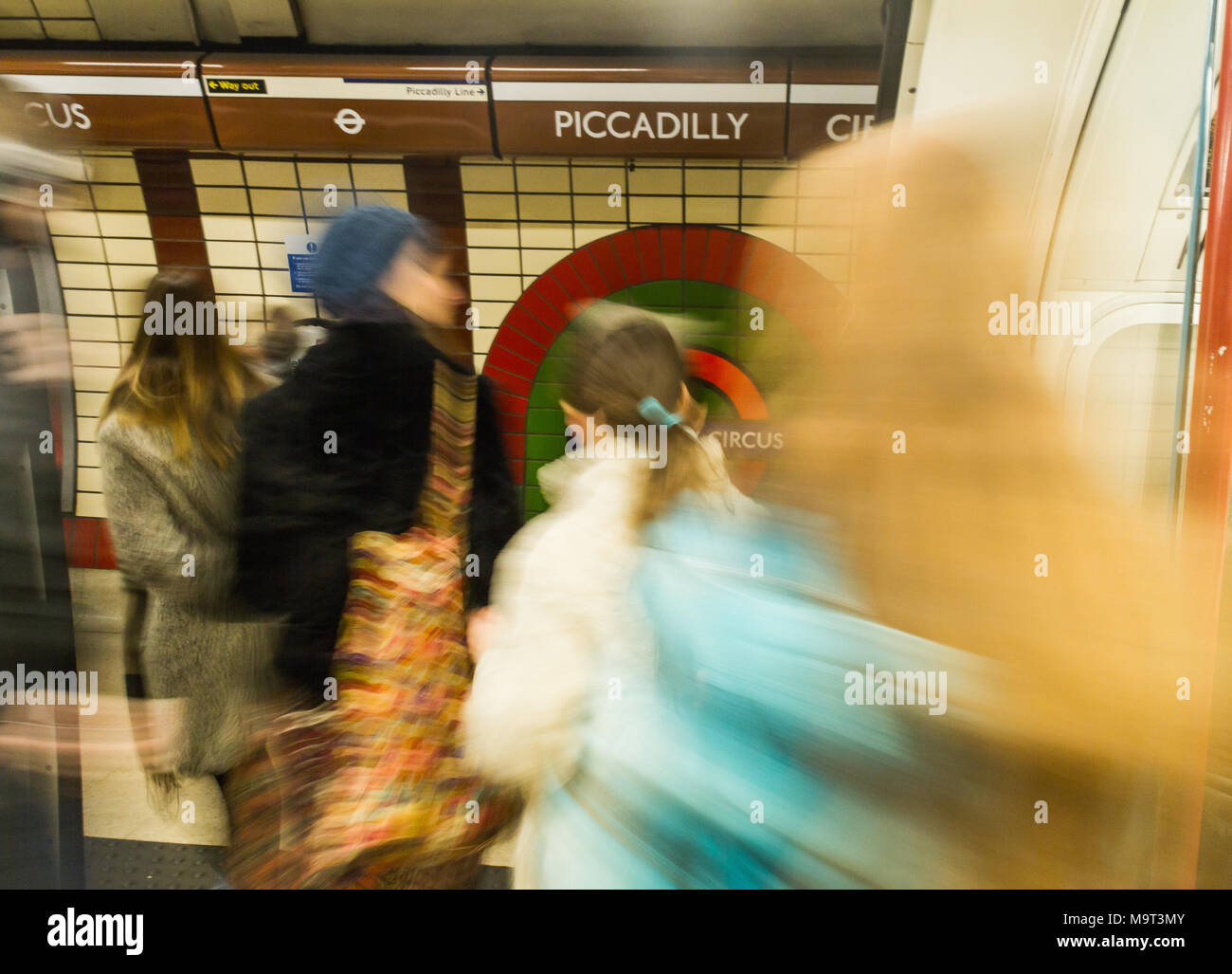 Los viajeros bajarse de un tren del metro de Londres en hora punta Foto de stock