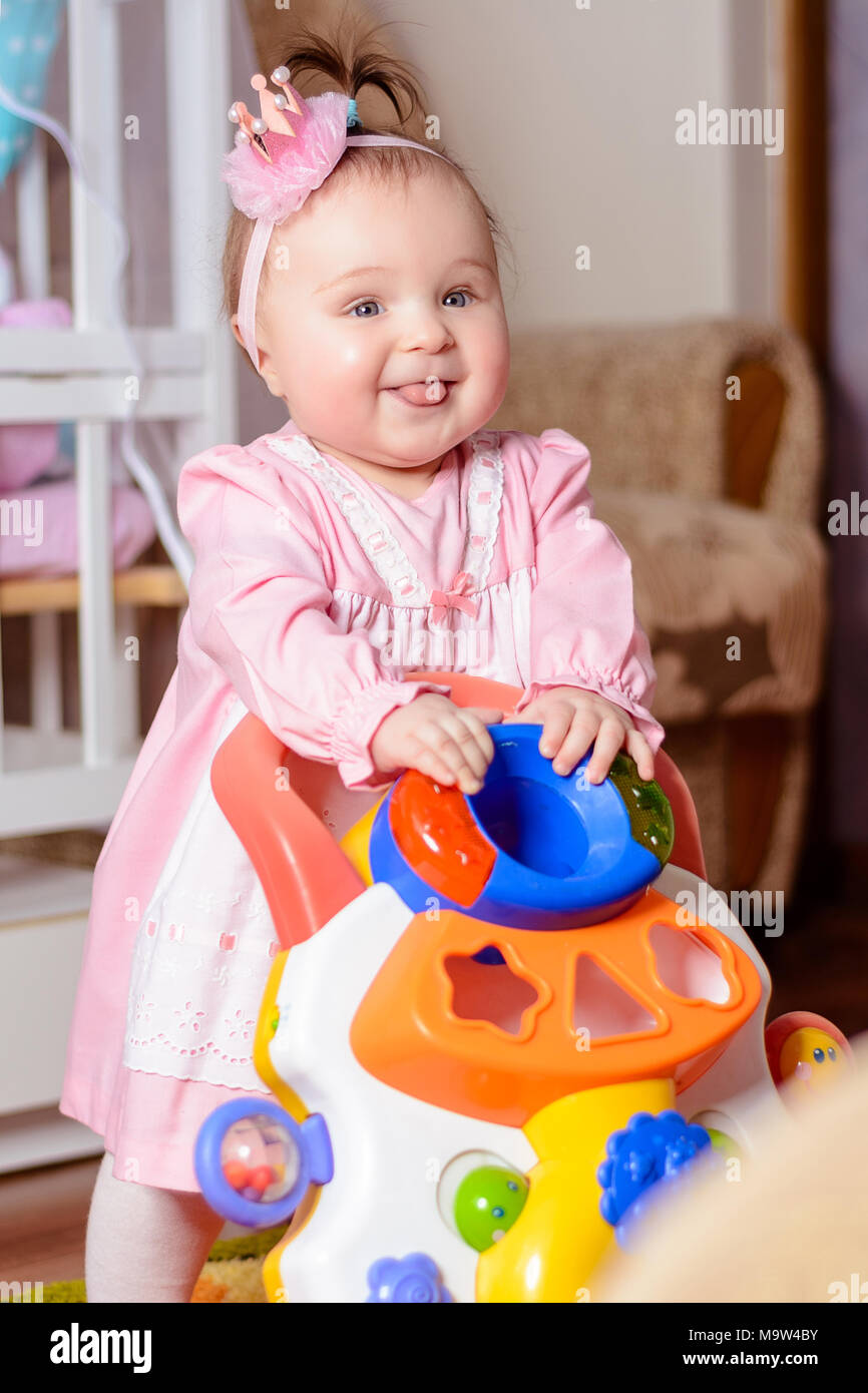 hermosa chica en un vestido rosado se ríe en una cama de bebé 2018 Fotografía stock - Alamy