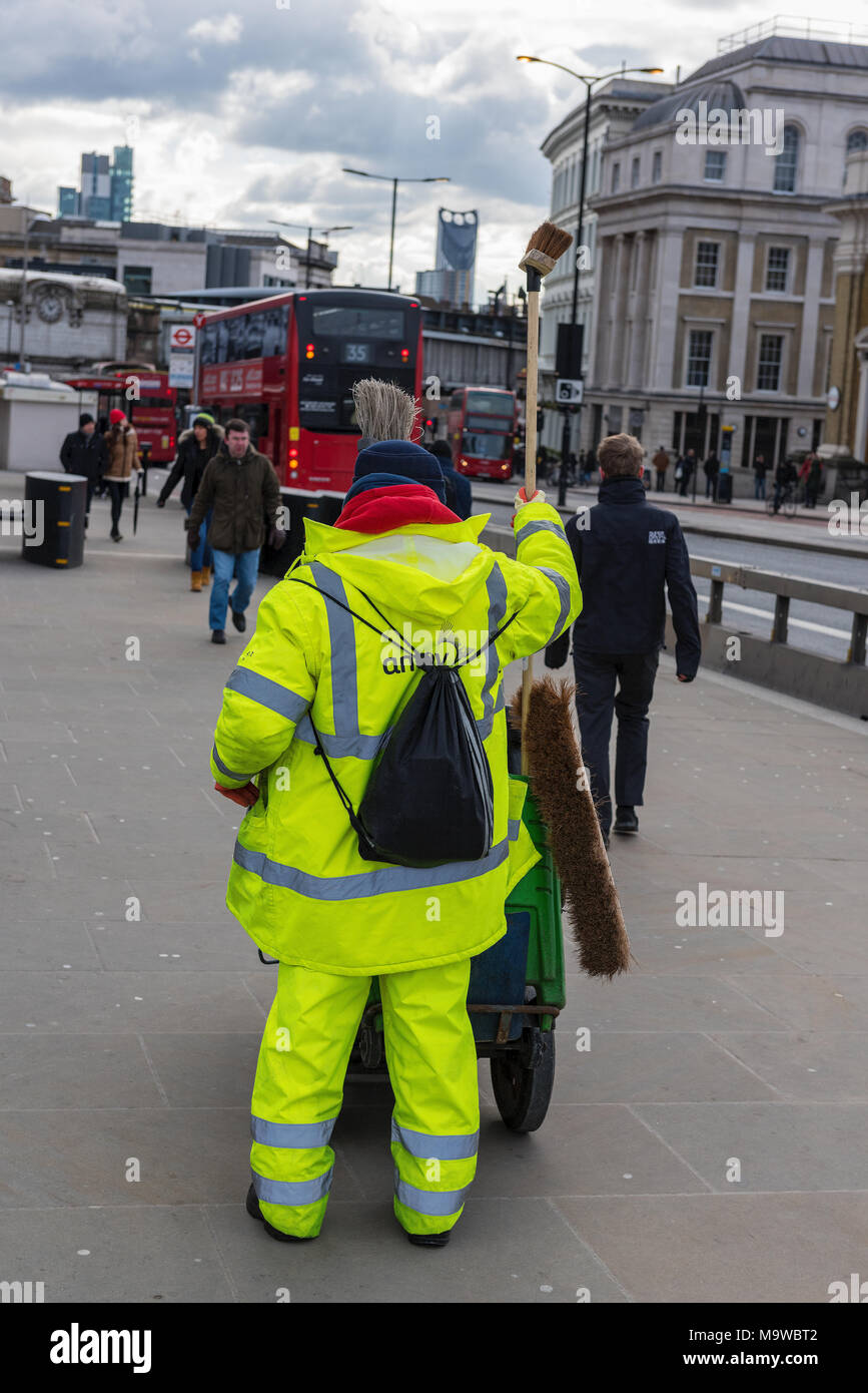 Un limpiador de la calle en el centro de Londres en el puente de southwark.  hombre de trabajo mantener las calles de la ciudad capital limpia y libre  de basura y tat