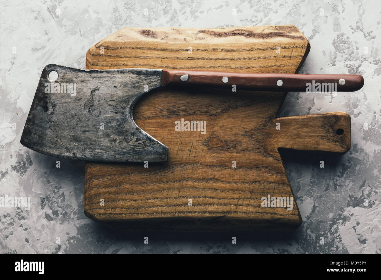 Antiguo ax rústico para la carne sobre una tabla de madera Foto de stock