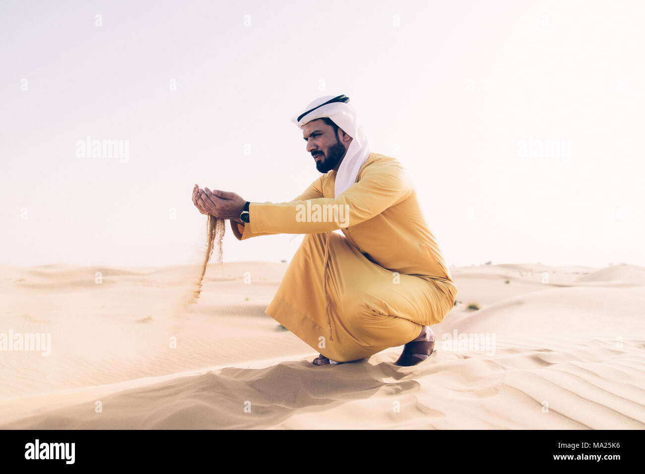 Hombre vestido con ropa tradicional de los EAU de pasar tiempo en el  desierto Fotografía de stock - Alamy
