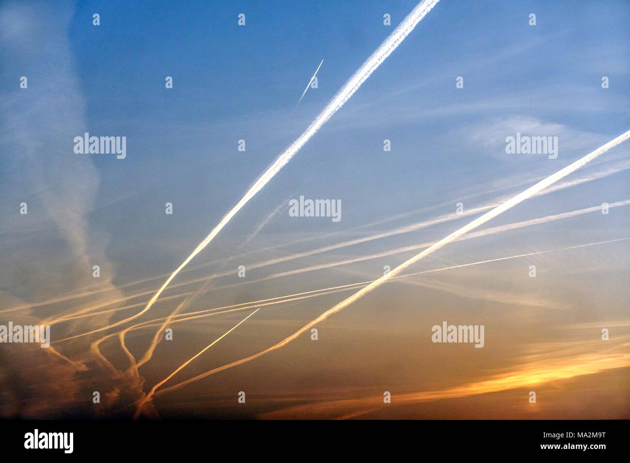 Senderos de vapor de avión sobre un cielo del amanecer Senderos de avión Cambia las emisiones de carbono climático, estelas químicas Foto de stock